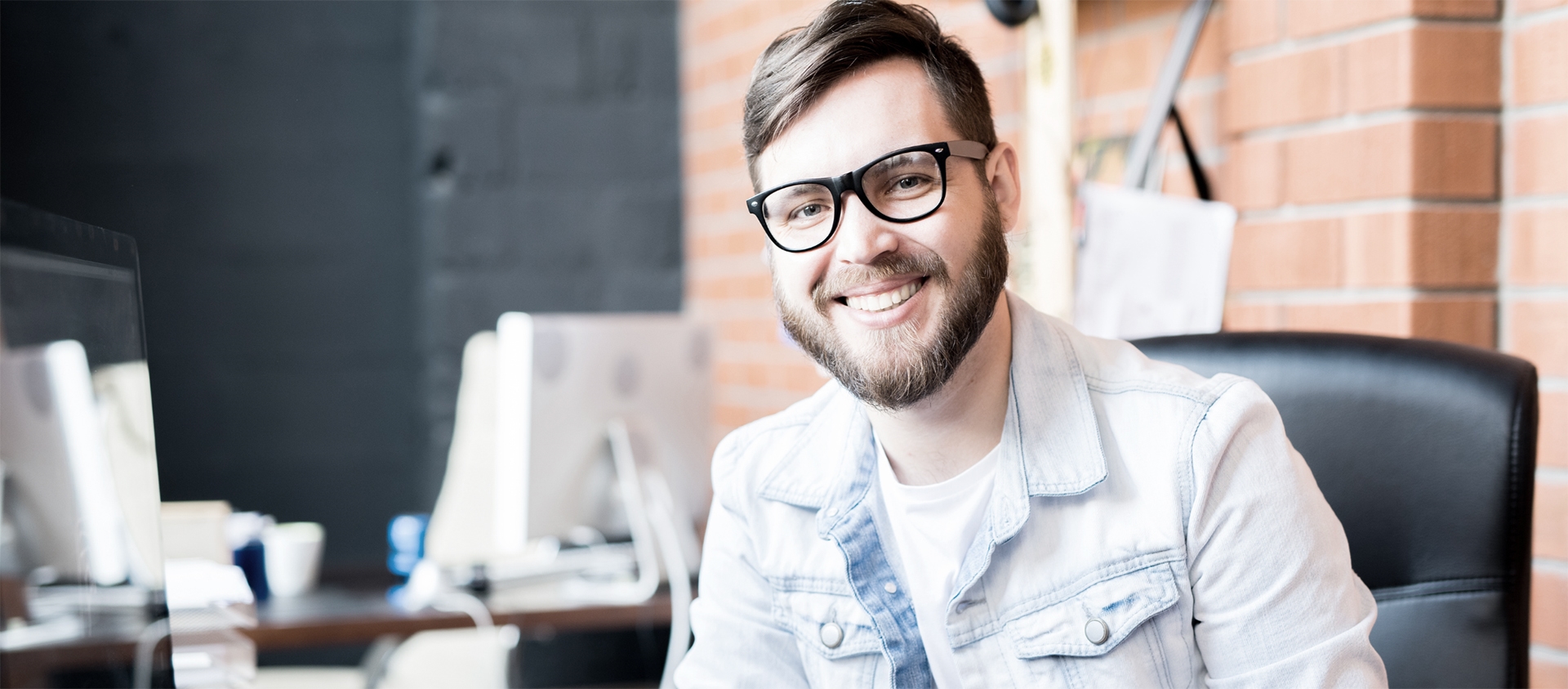 Man with glasses smiling at the camera